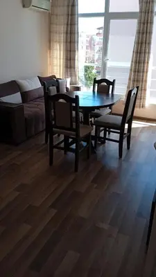 a living room with a table and chairs and a couch at Dunav-Lazur Apt.5 in Ravda