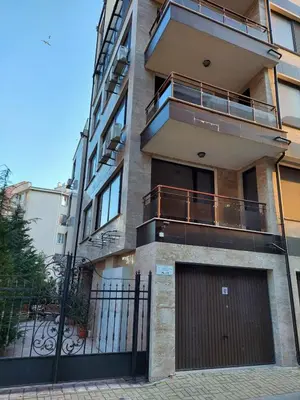 an apartment building with a gate and a garage at Студио Прованс Лариса in Pomorie
