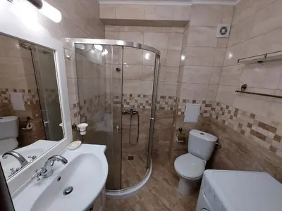 a bathroom with a shower and a sink and a toilet at Студио Прованс Лариса in Pomorie