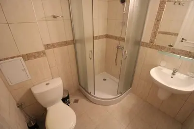 a bathroom with a shower and a toilet and a sink at Menada Casa del Sol Apartments in Sunny Beach