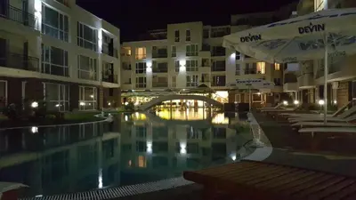 a swimming pool in front of some buildings at night at Menada Casa del Sol Apartments in Sunny Beach