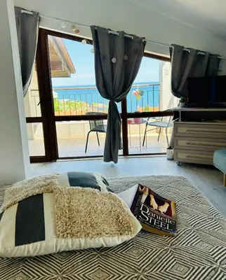 a bedroom with a bed with a view of the ocean at Sunrise place Eva in Sozopol