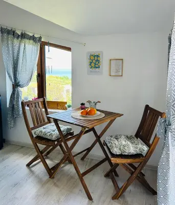 a dining room table with two chairs and a bowl of fruit at Sunrise place Eva in Sozopol