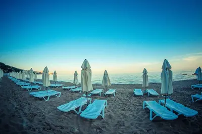 a row of chairs and umbrellas on a beach at Apartament with See View in Sveti Vlas