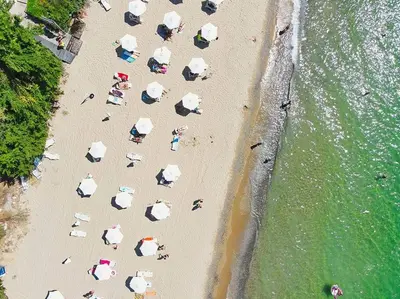 a group of people on a beach with umbrellas at Apartament with See View in Sveti Vlas