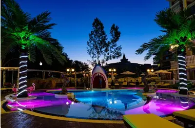 a pool with purple lights in a resort at night at Sweet Homes 6 in Sunny Beach