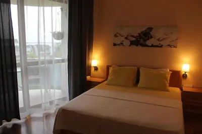 a bedroom with a bed and a large window at Apart complex Starfish със собствено паркомясто in Sveti Vlas