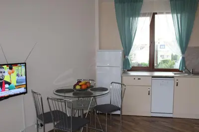 a kitchen with a table and chairs and a television at Apart complex Starfish със собствено паркомясто in Sveti Vlas