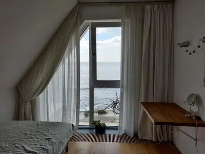 a bedroom with a large window with a view of the ocean at Beach Villa Varna - cosiness 4 meters from the sea in Varna City