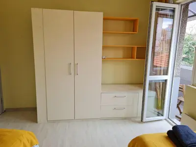 a bedroom with a white cabinet and a mirror at Spacious apartment 