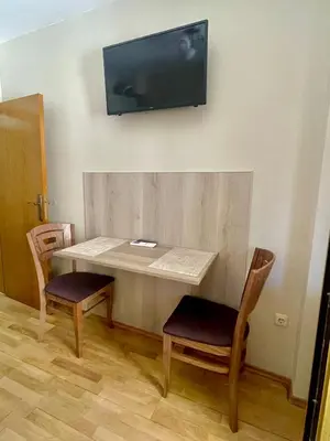 a table with two chairs and a television on a wall at Sunny in Varna City