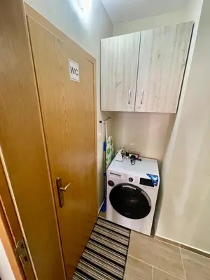a laundry room with a washer and dryer next to a door at Sunny in Varna City
