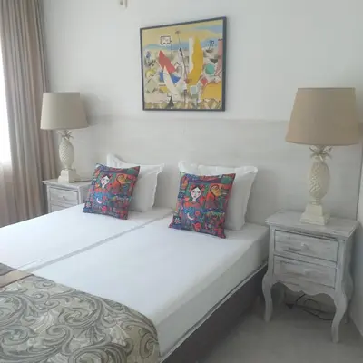 a bedroom with a bed with two night stands and two lamps at Z&Z Apartment in Sozopol