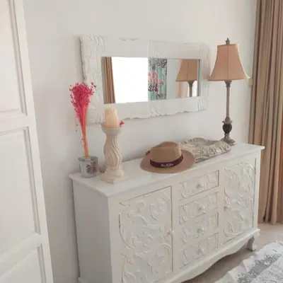 a white dresser with a mirror and a hat on it at Z&Z Apartment in Sozopol