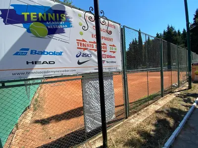 a fence on a tennis court with a sign on it at Two bedroom apartment in Trakia Sunny Beach in Sunny Beach
