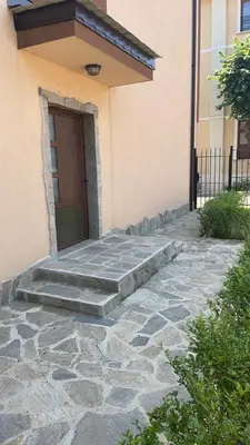a door of a house with a stone walkway leading to a door at Къща за гости “Недев” in Tsarevo