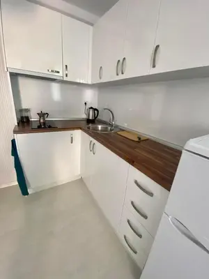 a kitchen with white cabinets and a sink at Apartman Kuba in Primorsko