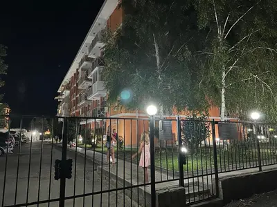 a woman standing next to a fence at night at Gerber Residence 2 in Sunny Beach