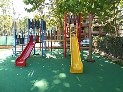 a playground with colorful slides and a tree at Gerber Residence 2 in Sunny Beach