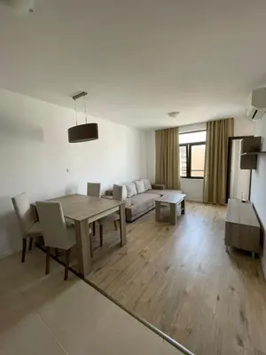a living room with a table and a couch at Aivazovski park - Pomorie SP apartments in Pomorie