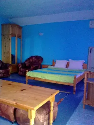 a room with a bed and a table in it at Вила Синя Иглика in Kosharitsa