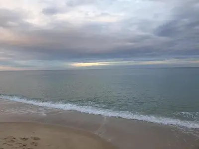 a beach with a cloudy sky and the ocean at Seaside 1-BR Apartment with Pool Access in Byala