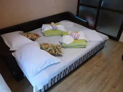 a large bed with pillows and towels on it at Апартамент Хармония in Sozopol