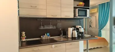 a small kitchen with a sink and a microwave at Апартамент BLUE SUMMER - уют, близо до морето in Burgas City