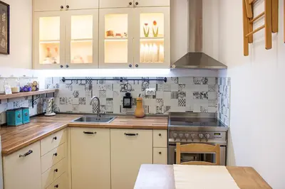 a kitchen with white cabinets and a sink at COZZIE by RV Apartments in Varna City