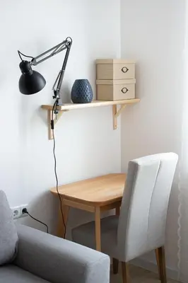 a desk and a lamp on a wall next to a chair at COZZIE by RV Apartments in Varna City