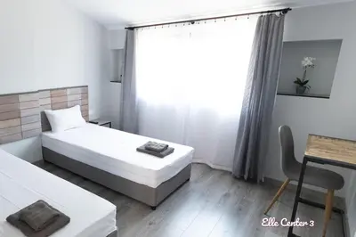 a bedroom with two beds and a table and a window at Elle Center by RV Apartments - TOP center in Varna City