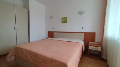 a small bedroom with a bed and a cabinet at Апартамент Полюси 2 in Sunny Beach