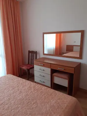 a bedroom with a dresser with a mirror and a bed at Апартамент Полюси 2 in Sunny Beach