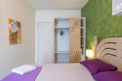 a bedroom with a white bed and a green wall at Solero in Pomorie