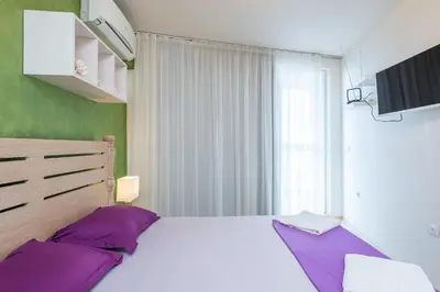 a bedroom with a large bed with purple pillows at Solero in Pomorie