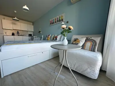a bedroom with a large bed and a table at Studio B28 Sunny Island Chernomorez in Chernomorets