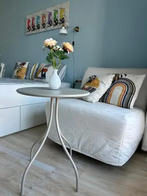 a table with a vase on it next to a bed at Studio B28 Sunny Island Chernomorez in Chernomorets