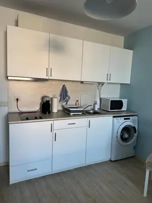 a kitchen with white cabinets and a washing machine at Studio B28 Sunny Island Chernomorez in Chernomorets