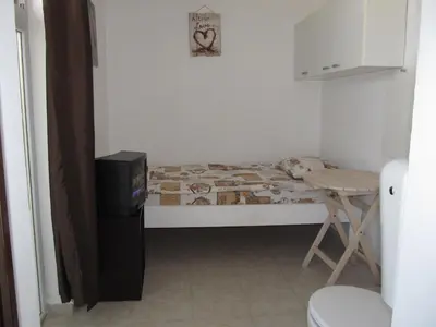 a small bedroom with a bed and a small television at Apartments and studios in Cote d’Azure in Sunny Beach