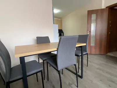 a wooden table and chairs in a room at Apartment Starfish in Varna City