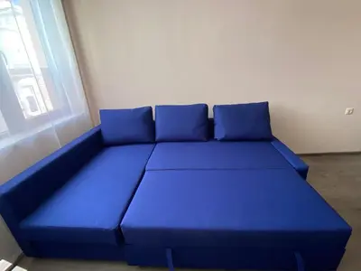 a blue couch with blue pillows in a room at Apartment Starfish in Varna City