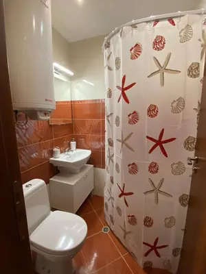 a bathroom with a toilet and a shower curtain at Apartment Starfish in Varna City