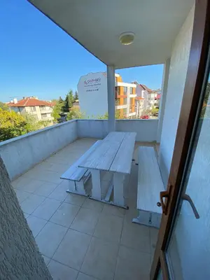 a wooden bench on a balcony with a table at Апартамент 