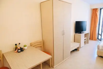 a room with a bed and a table and a tv at One bedroom guest suite in Sunny Beach