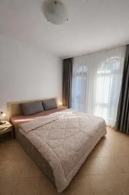 a bedroom with a large bed in front of a window at One bedroom guest suite in Sunny Beach