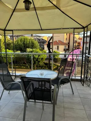 a table and chairs on top of a balcony with a table and chairs at Къща за гости Деневи in Primorsko