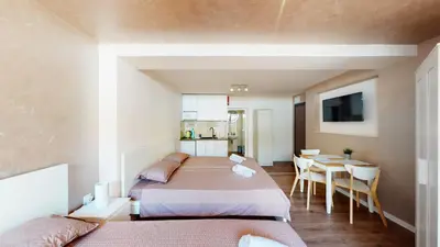 a bedroom with two beds and a table and a kitchen at Markoni 5 in Burgas City