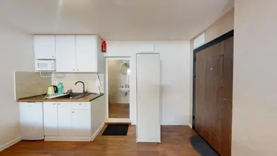 a kitchen with white cabinets and a sink and a door at Markoni 5 in Burgas City