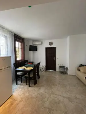 a living room with a table and chairs and a couch at Apartament in The Cliff Beach & Spa **** in Obzor