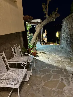 a couple of chairs sitting on a patio at night at Къща за гости Кая in Sozopol